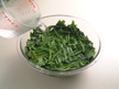 Photo of puring water into cooked spinach.