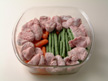 Image of pork and vegetables arranged ready for microwave cooking.