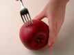 Image of puncturing apple skin with a fork.