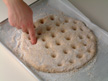Image of poking holes on the dough with fingers.
