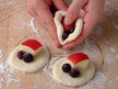 Image of sealing a dough in which there are two blueberries and a slice of apple.